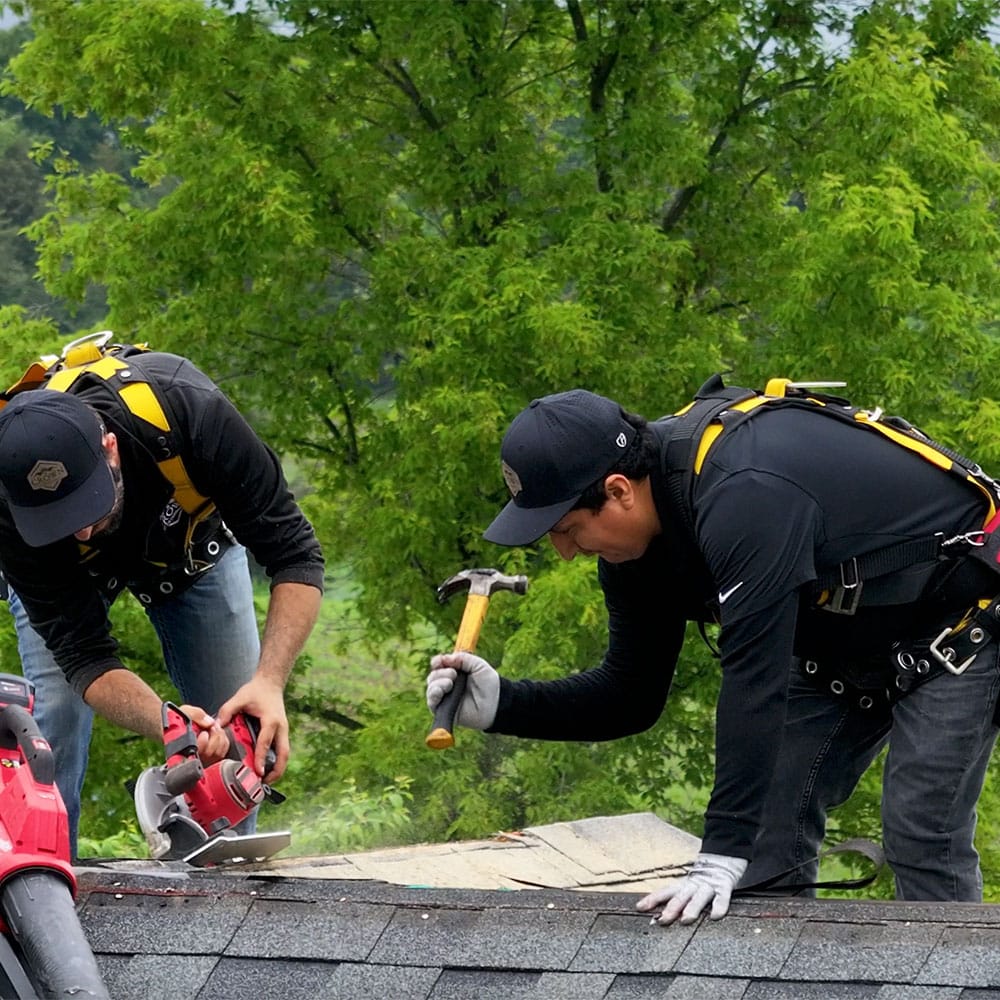 BN Covered Exteriors roofing crew installing shingles on a home